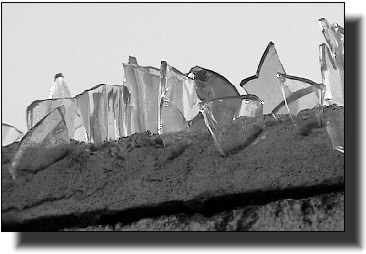 Security glass cemented on the top of a wall